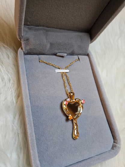 Mirror of Venus Necklace displayed in elegant jewelry box with golden and pink accents.